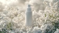 White cosmetic pump bottle surrounded by delicate white gypsophila flowers in soft morning light against dreamy bokeh background, natural skincare concept.
