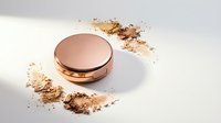 Compact powder makeup with scattered cosmetic dust on white background for beauty and skincare applications.