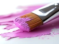 Paint brush with bright pink paint on white surface, macro photography showing fine bristle details and wet paint texture for artistic and creative projects.
