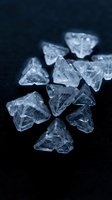 Raw uncut diamonds scattered on dark surface showing natural crystal formations and transparent clarity for luxury jewelry design concepts.