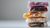 Stack of colorful natural gemstones or crystal slices with translucent texture and mineral inclusions on neutral background for jewelry making or healing practices.