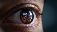 Macro close-up of a human eye with digital interface icons reflected in the iris, symbolizing technology, surveillance, and futuristic vision.