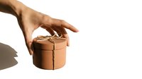 Hand reaching for brown leather wrapped gift box on white background for holiday shopping and present giving occasions.