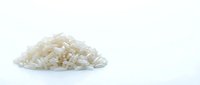 Pile of uncooked white long grain rice isolated on white background, ready for cooking or food design projects.