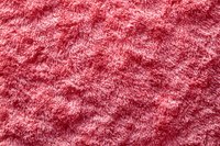 Soft pink fluffy carpet texture with long pile fibers creating luxurious plush surface pattern, suitable for interior design and textile backgrounds.