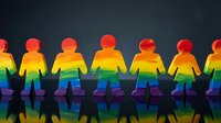 Rainbow colored paper cutout figures holding hands in unity and diversity concept for pride celebration and inclusion campaigns.