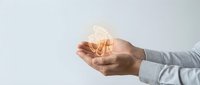 Hand holding glowing brain symbol representing innovation, creativity, and intelligent thinking for business and technology concepts.
