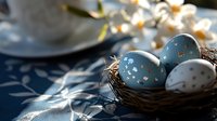 Decorative Easter eggs in blue and white with gold polka dots nestled in small natural nest. Soft morning light creates gentle shadows. Spring holiday composition.