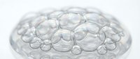 Transparent glass bubbles cluster together forming an organic dome structure on white background, isolated for design and overlay use.