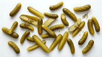 Pickled gherkins and dill sprigs arranged on white background, ready for food packaging, recipe blogs, culinary websites, and restaurant menus.