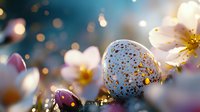 Decorative Easter egg with gold speckles among spring cherry blossoms against blurred bokeh background creates magical seasonal atmosphere.