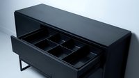 Modern black sideboard with open drawer revealing compartmentalized storage interior for organized home decor and dining room furniture solutions.