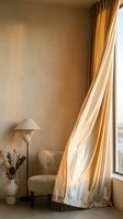 Warm minimalist interior corner with beige armchair, floor lamp, dried flowers in ceramic vase, and flowing golden curtains filtering natural light through window.