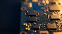 Close-up of computer motherboard with microchips and electronic components in warm lighting for technology and hardware concepts.