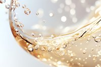 Champagne wave with sparkling bubbles in wineglass creating dynamic splash and bokeh effect against light background, macro photography.