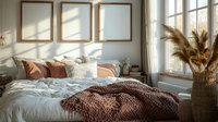 Cozy bedroom interior with sunlight casting shadows through window, empty wooden frames above bed, white bedding, terracotta pillows and dried pampas grass decoration.