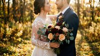 Romantic newlywed couple embracing in golden autumn sunlight with burgundy and peach bridal bouquet for wedding photography and love concepts.