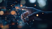 Futuristic hand touching digital sphere with glowing network connections and orange light particles against dark background, representing global technology.