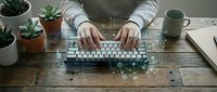 Hands typing on a keyboard at a wooden desk with glowing digital network overlay, plants, and a mug, symbolizing tech and connectivity.