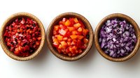 Three wooden bowls filled with colorful diced vegetables including red peppers, orange carrots, and purple cabbage for cooking preparation.