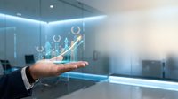 Businessman hand presenting holographic growth chart with upward arrow and gears in modern office environment for business success presentations.