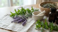 Fresh lavender and mint herbs with mortar and pestle on linen cloth. Natural aromatherapy ingredients for essential oils and herbal remedies preparation.