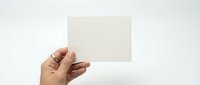 Hand holding blank white card mockup template for business presentation design on clean background.