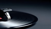 Vintage vinyl record with turntable needle in dramatic lighting showcasing analog music technology and retro audio equipment for nostalgic sound reproduction.