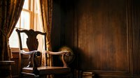 Young male figure with athletic build, standing in classical contrapposto pose by ornate window with golden curtains in luxurious interior. Warm lighting emphasizes muscular form and elegant period furniture for fine art and gallery use.