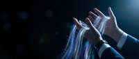Young male hands manipulating glowing blue digital data streams and light particles against dark background, representing technology, innovation, and digital transformation for business concepts.