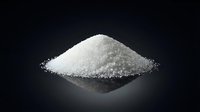 White granulated sugar pile on dark reflective surface for cooking and baking ingredients in kitchen culinary applications.