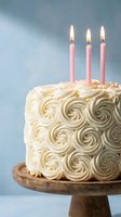 Elegant white birthday cake with rosette frosting and three pink candles on wooden stand against soft blue background for celebration occasions.