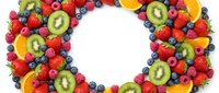 Fresh fruit wreath with strawberries, kiwi, blueberries and orange slices arranged in circle on white background for healthy eating and nutrition concepts.