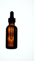 Amber glass dropper bottle with black pipette cap on white background, suitable for essential oils, serums, and cosmetic packaging.