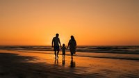 Family with two children standing together on beach at sunset, holding hands in shallow water during golden hour, suitable for travel and lifestyle marketing.