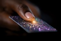 African American woman's finger touching glowing smartphone screen with magical sparkle effect and purple bokeh lights on dark background.