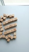 Wooden letter blocks spelling growth, trade and value on a light surface, representing business strategy, investment and financial concepts.