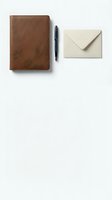 Brown leather notebook with black pen and cream envelope on white background for business correspondence and office stationery needs.