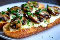Toasted baguette slice topped with melted cheese, sauteed mushrooms and fresh chopped parsley on white plate, close up view of gourmet open sandwich.