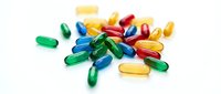 Colorful vitamin capsules and pills scattered on white background for health supplement and pharmaceutical design projects.