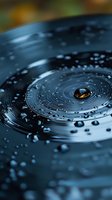 Water droplets forming concentric ripples on dark blue surface with central droplet reflecting warm light, ideal for wellness concepts.