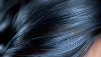 Close-up of lustrous black hair with natural shine and smooth texture showing healthy strands and sleek appearance for beauty and haircare concepts.