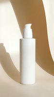 White pump dispenser bottle mockup on beige background with elegant shadows, blank label for skincare or cosmetic branding design.