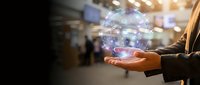 Businessman holding glowing digital sphere with network connections in modern office environment representing global connectivity and technology innovation.