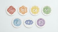Chakra symbols isolated on white background, seven colorful meditation icons with Sanskrit characters representing root, sacral, solar plexus, heart, throat, third eye and crown energy centers for wellness and spiritual design projects.