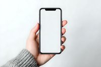 Hand holding modern smartphone with blank white screen against neutral background. Perfect for app or website mockup.