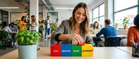 Young businesswoman building colorful blocks with business words in modern office workspace with diverse team collaborating in background.