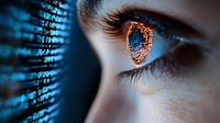 Digital binary code reflected in close-up eye with orange and blue glow, representing artificial intelligence, machine learning and future technology concept.