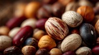 Mixed nuts and legumes collection featuring walnuts, almonds, hazelnuts, kidney beans and various seeds in natural brown tones for healthy eating concepts.