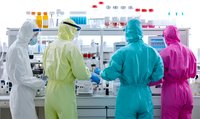Laboratory scientists in protective suits and masks working with test tubes and equipment in modern research facility during virus outbreak investigation.